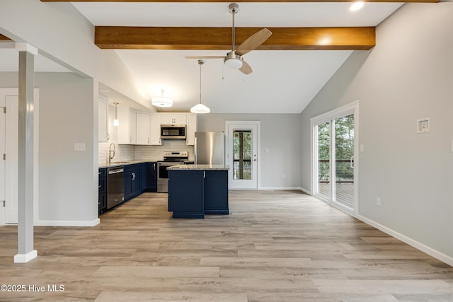 11 White Ln, Oak Island, NC 28465 - kitchen with appliances with stainless steel finishes, blue cabinets, a ceiling fan, white cabinetry, and backsplash