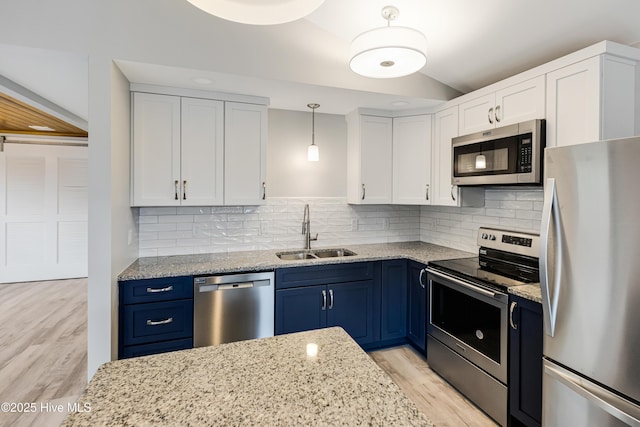 kitchen featuring sink, white cabinetry, stainless steel appliances, light stone counters, and blue cabinets