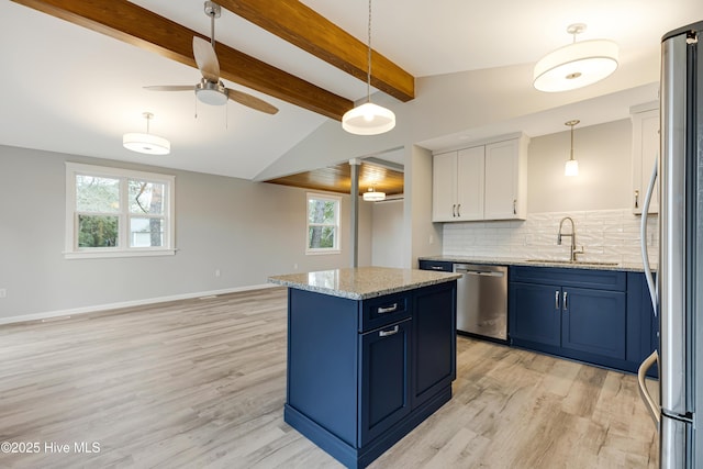 11 White Ln, Oak Island, NC 28465 - kitchen with blue cabinetry, appliances with stainless steel finishes, decorative backsplash, and light wood-type flooring