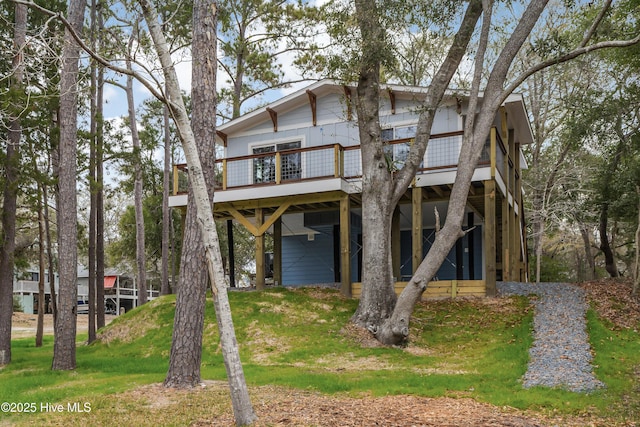 view of front of home with a deck and a front lawn