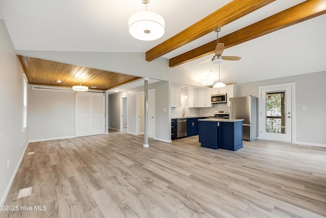 kitchen with white cabinetry, a kitchen island, stainless steel appliances, blue cabinets, and a kitchen bar