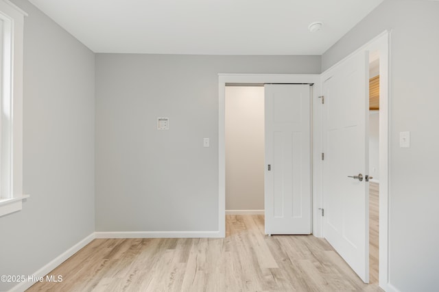 unfurnished bedroom with light hardwood / wood-style floors and a closet