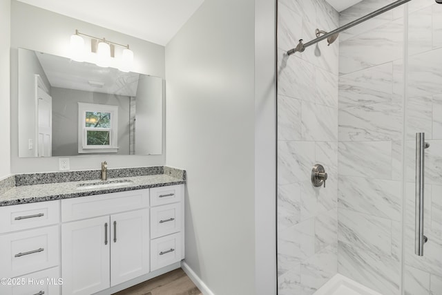 bathroom with vanity, hardwood / wood-style floors, and a tile shower