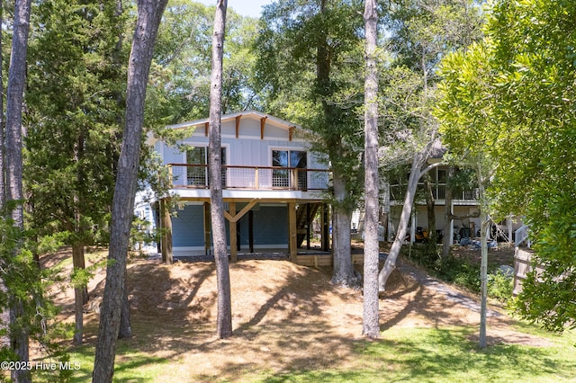 11 White Ln, Oak Island, NC 28465 - back of property featuring a carport, a wooden deck, board and batten siding, and driveway