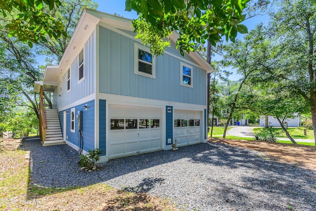 11 White Ln, Oak Island, NC 28465 - view of property exterior featuring board and batten siding, stairs, an attached garage, and driveway