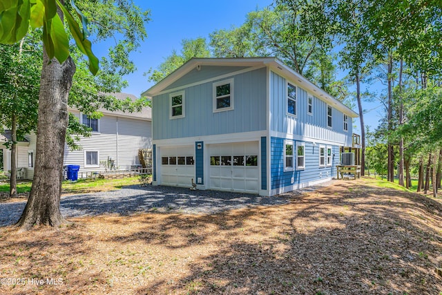 11 White Ln, Oak Island, NC 28465 - view of property exterior featuring gravel driveway, a garage, and board and batten siding