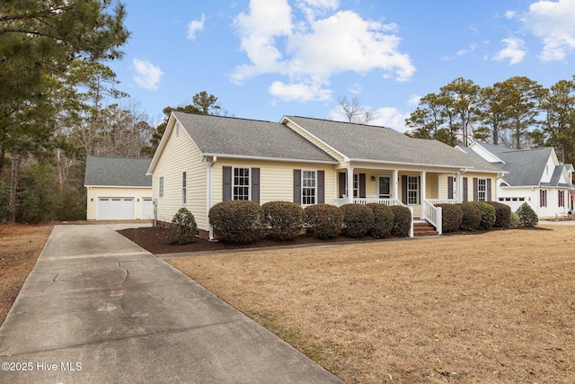 view of front of property featuring a garage, an outbuilding, a front yard, and covered porch