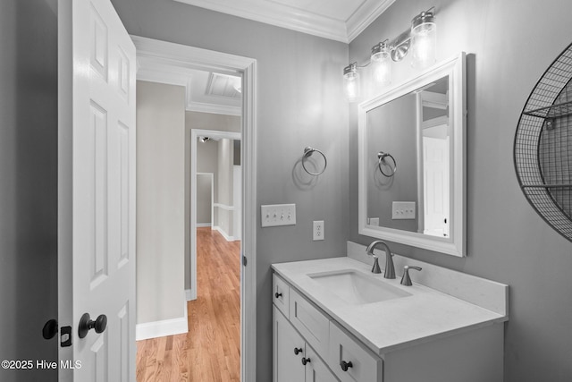 bathroom with crown molding, hardwood / wood-style floors, and vanity