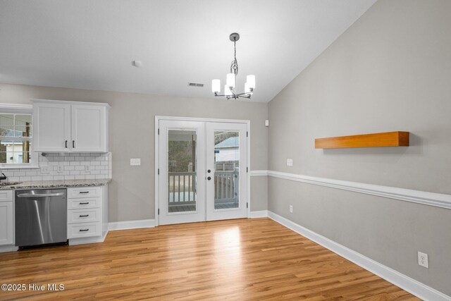 unfurnished living room with rail lighting, light wood-type flooring, french doors, beam ceiling, and ceiling fan with notable chandelier