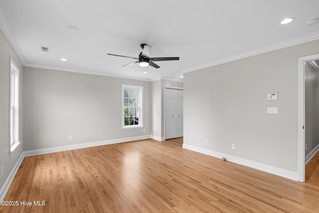 empty room with ceiling fan, a wealth of natural light, ornamental molding, and light wood-type flooring