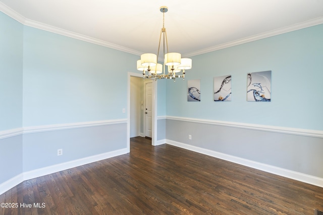 spare room with crown molding, dark hardwood / wood-style floors, and a chandelier