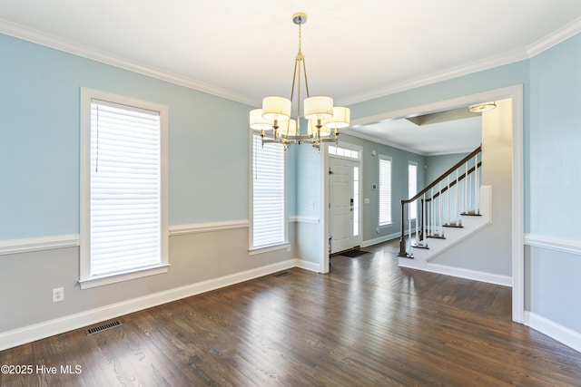 entrance foyer featuring an inviting chandelier, crown molding, and dark wood-type flooring