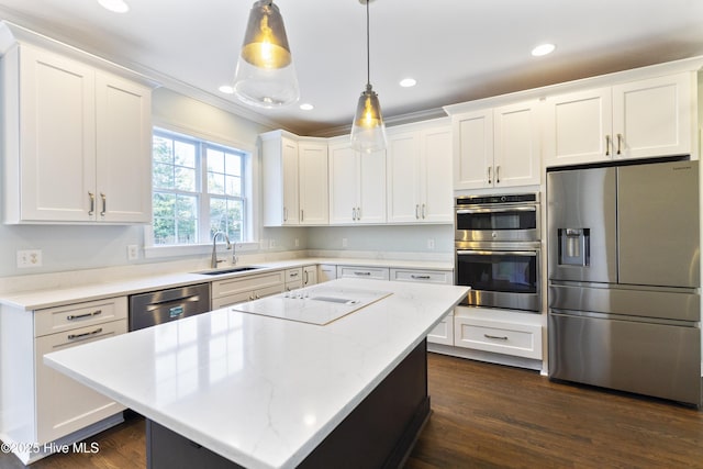 kitchen featuring pendant lighting, sink, appliances with stainless steel finishes, white cabinets, and a kitchen island