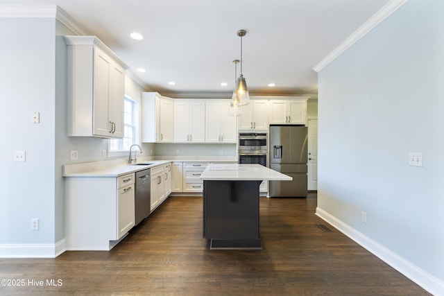 kitchen with crown molding, appliances with stainless steel finishes, a kitchen island, pendant lighting, and white cabinets