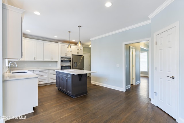 kitchen featuring sink, decorative light fixtures, a kitchen island, stainless steel appliances, and white cabinets