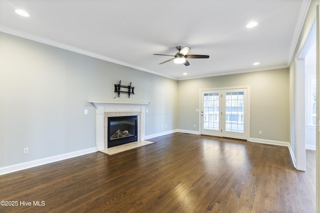 unfurnished living room with a tile fireplace, dark hardwood / wood-style floors, ceiling fan, and crown molding