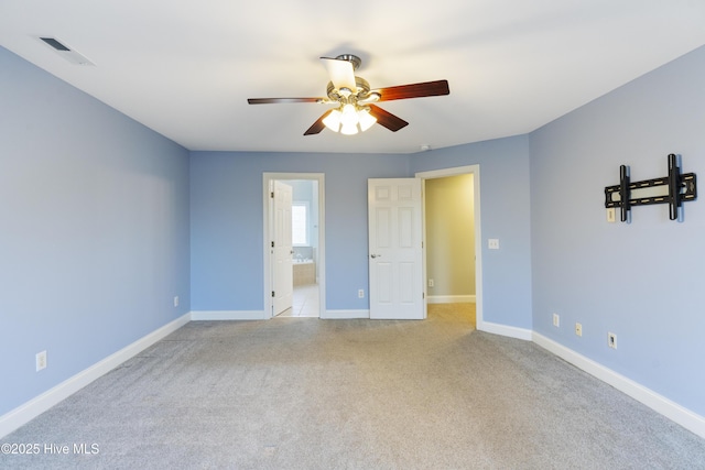 unfurnished bedroom with light colored carpet, ceiling fan, and ensuite bathroom