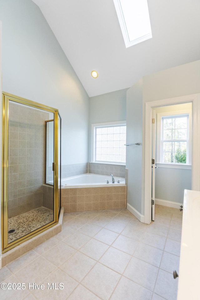 bathroom featuring tile patterned floors, lofted ceiling with skylight, and separate shower and tub