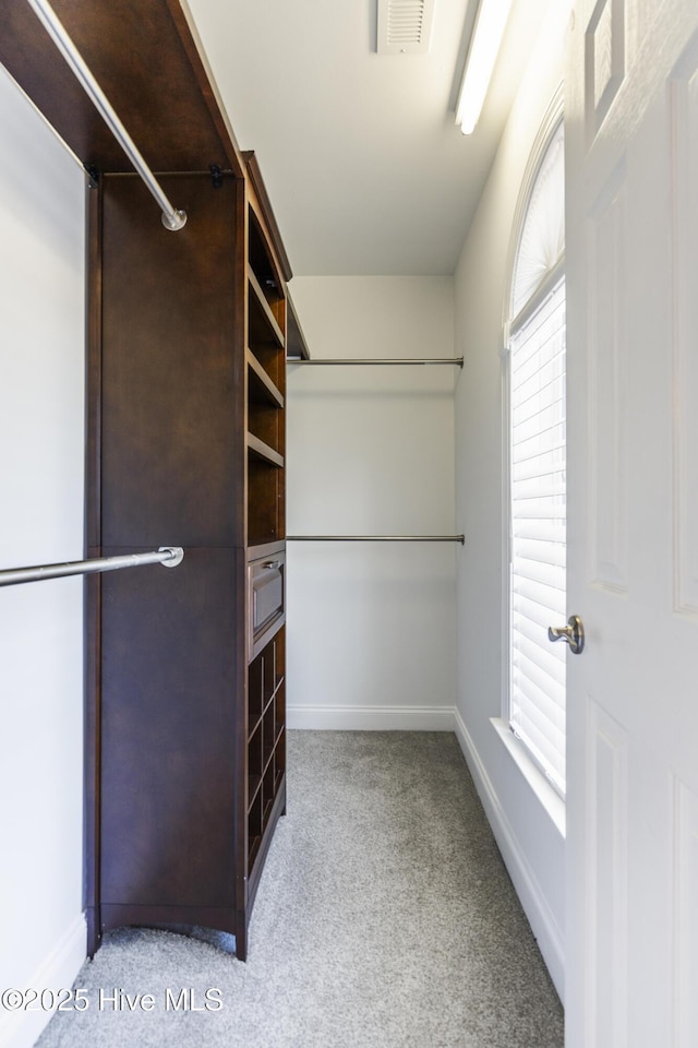 walk in closet featuring light carpet