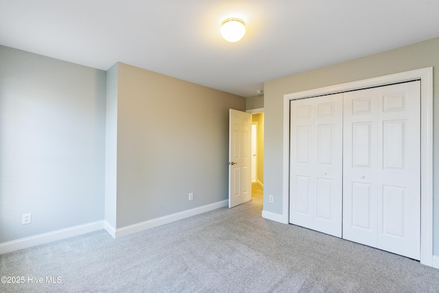 unfurnished bedroom featuring light colored carpet and a closet