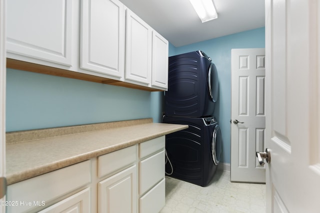 washroom with cabinets and stacked washer and clothes dryer