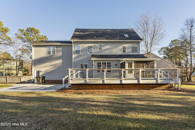 back of property featuring a patio, a deck, a lawn, and a sunroom