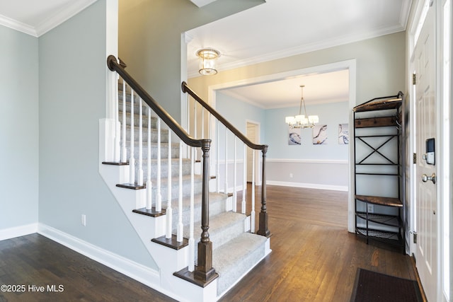 stairway with hardwood / wood-style flooring, ornamental molding, and a chandelier