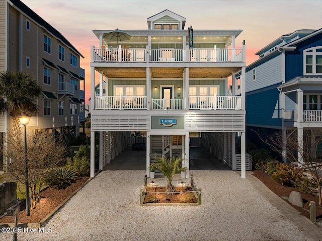 coastal home with board and batten siding, driveway, and a carport