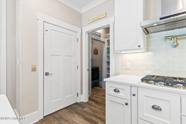 kitchen featuring stainless steel gas cooktop, exhaust hood, light countertops, backsplash, and dark wood-style floors