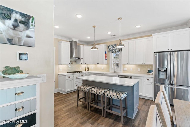 kitchen featuring white cabinetry, light countertops, wall chimney range hood, stainless steel fridge with ice dispenser, and a kitchen bar