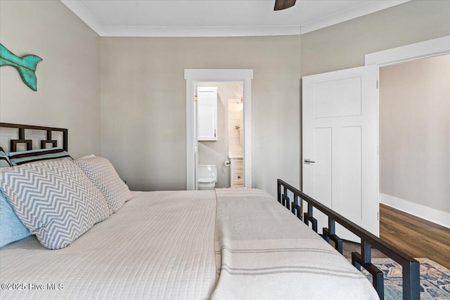 bedroom featuring ceiling fan, ensuite bathroom, wood finished floors, baseboards, and crown molding