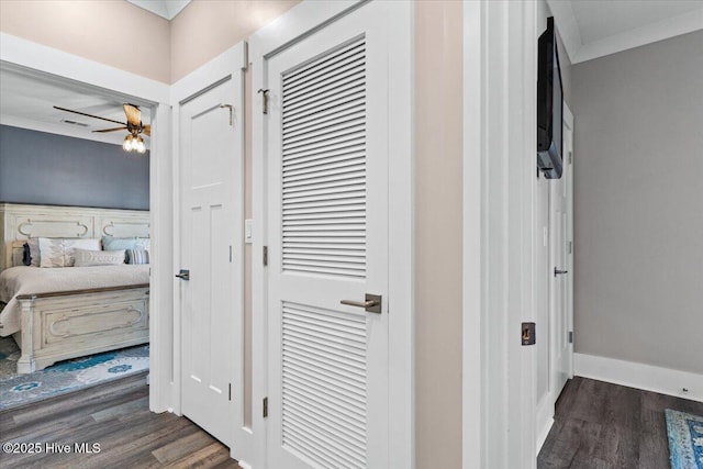 corridor with crown molding, baseboards, and wood finished floors