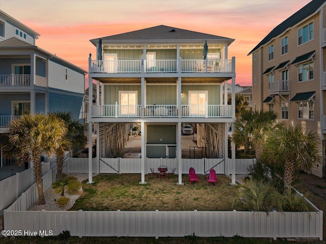 beach home featuring board and batten siding, a gate, a fenced backyard, and stairway