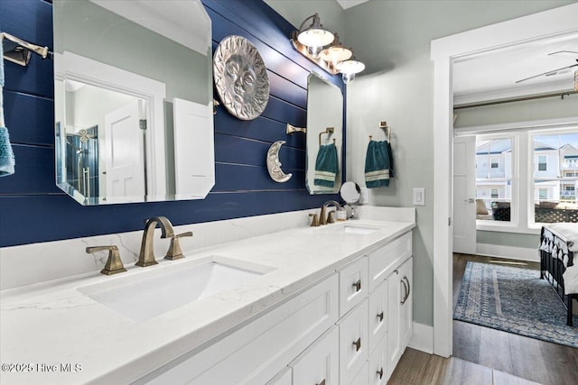 full bathroom featuring double vanity, wood finished floors, and a sink