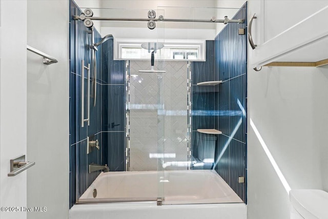 full bathroom featuring toilet and bath / shower combo with glass door