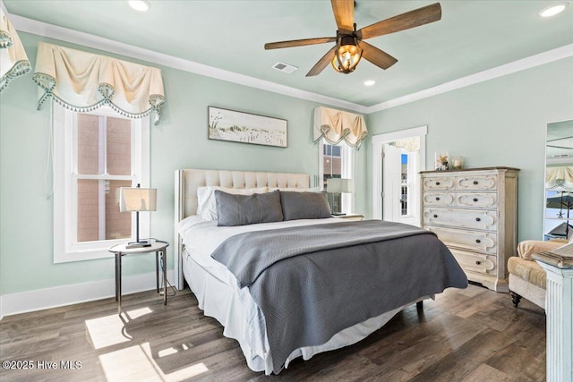 bedroom featuring baseboards, wood finished floors, visible vents, and crown molding