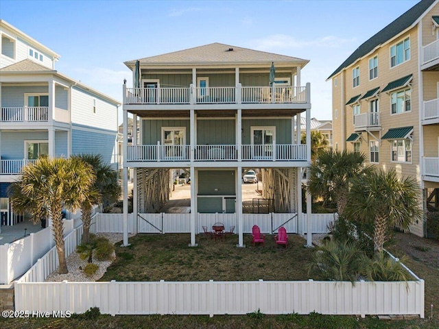 beach home featuring board and batten siding and fence private yard