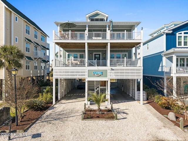 coastal home featuring a carport, gravel driveway, and board and batten siding