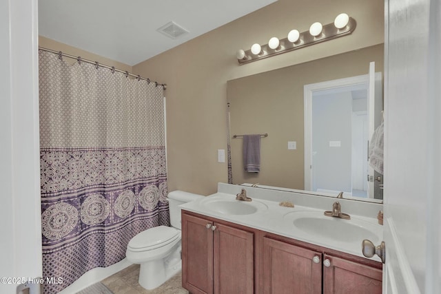 bathroom featuring toilet, vanity, and curtained shower