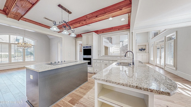 kitchen featuring sink, hanging light fixtures, a center island, and an inviting chandelier