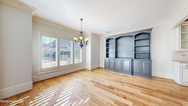 unfurnished dining area with ornamental molding, light hardwood / wood-style floors, and a notable chandelier