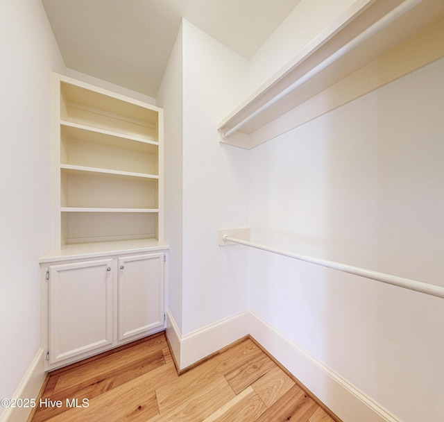 walk in closet with light wood-type flooring