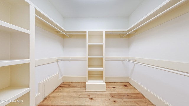 walk in closet with light hardwood / wood-style flooring