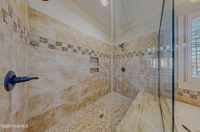 bathroom with ornamental molding and tiled shower