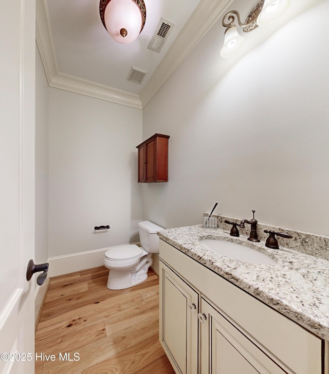 bathroom featuring toilet, crown molding, wood-type flooring, and vanity