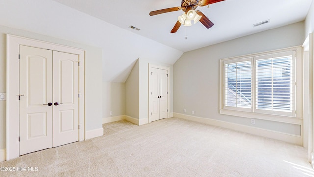 unfurnished bedroom featuring ceiling fan, light carpet, and lofted ceiling