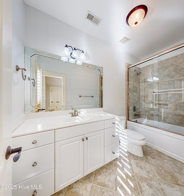 full bathroom with enclosed tub / shower combo, vanity, and toilet