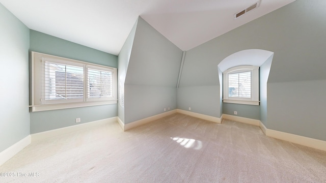 bonus room featuring lofted ceiling and light colored carpet