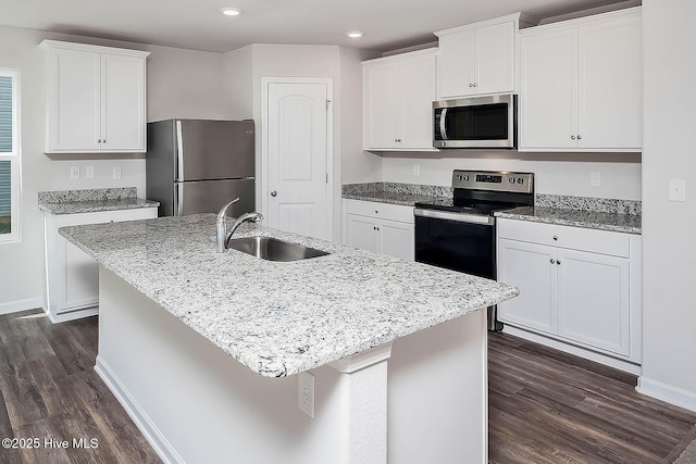 kitchen with sink, white cabinetry, appliances with stainless steel finishes, and an island with sink