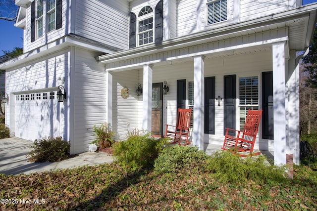 entrance to property with covered porch and a garage